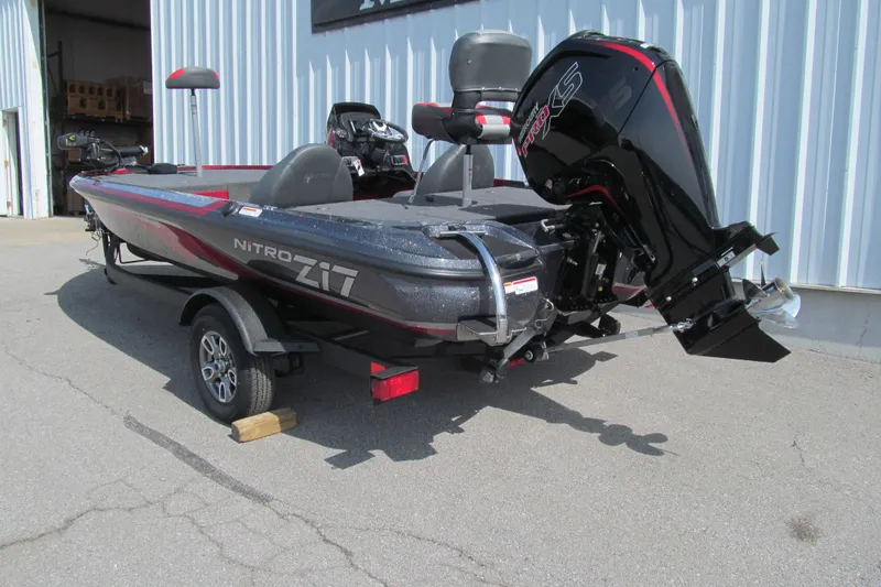 Slide: The Image of 2026 Nitro Z17 boat with powerful outboard motor, parked outside a warehouse. - 92