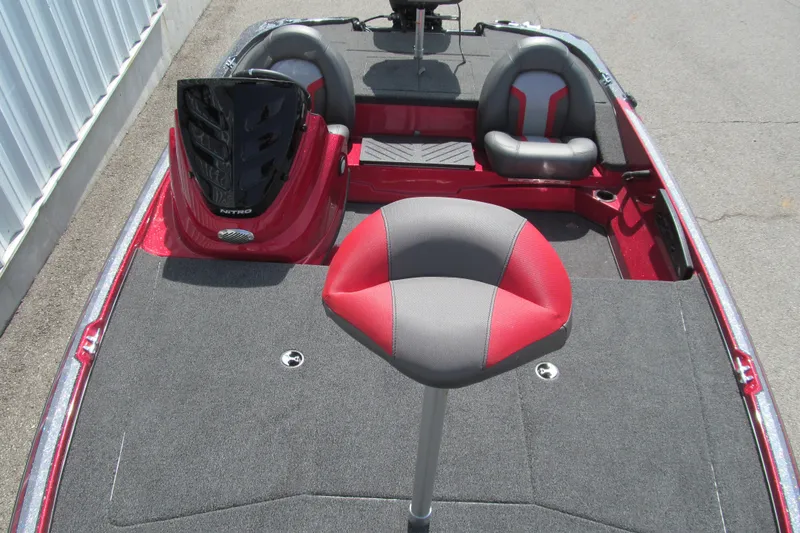 Slide: The Image of 2026 Nitro Z17 boat interior with red and gray seating, carpeted deck, and steering console. - 99