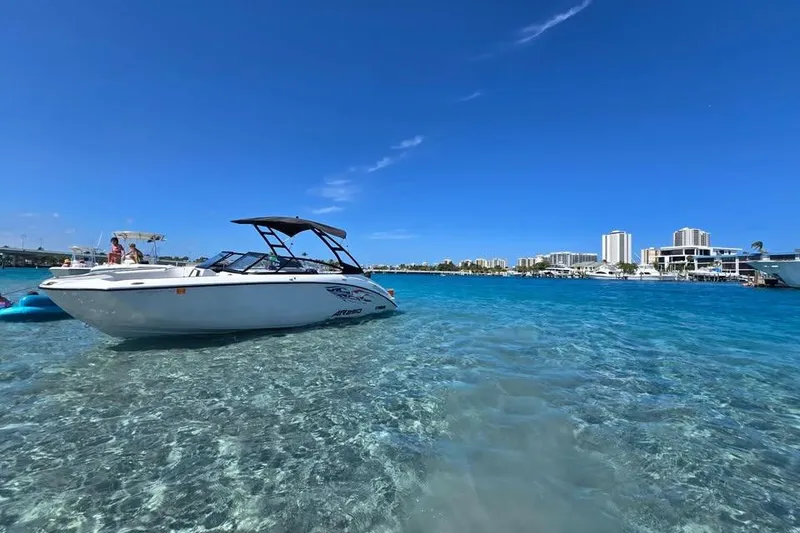 Slide: The Image of 2025 Yamaha Boats AR250 on trailer, white exterior, parked outdoors in sunny setting. - 1