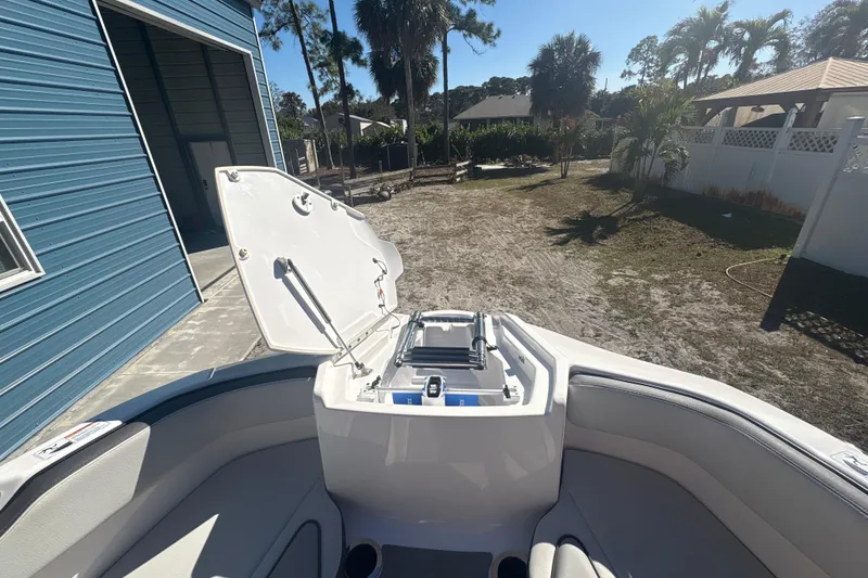 Slide: The Image of 2025 Yamaha Boats AR250 interior with modern seating and steering, set against a sunny backdrop. - 16