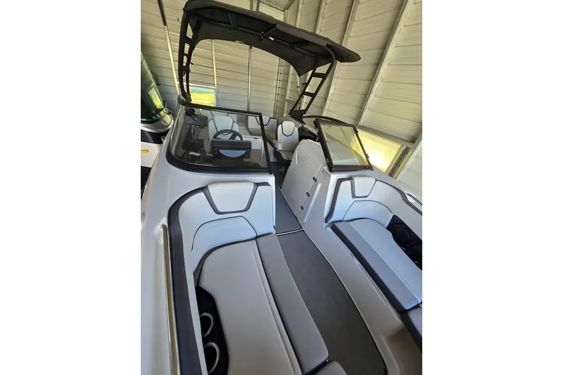 Slide: The Image of 2025 Yamaha Boats AR250 on trailer, parked beside a blue building, under clear sky. - 3