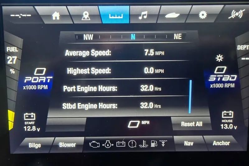 Slide: The Image of 2025 Yamaha Boats AR250 with open storage compartment, parked near a blue building. - 8