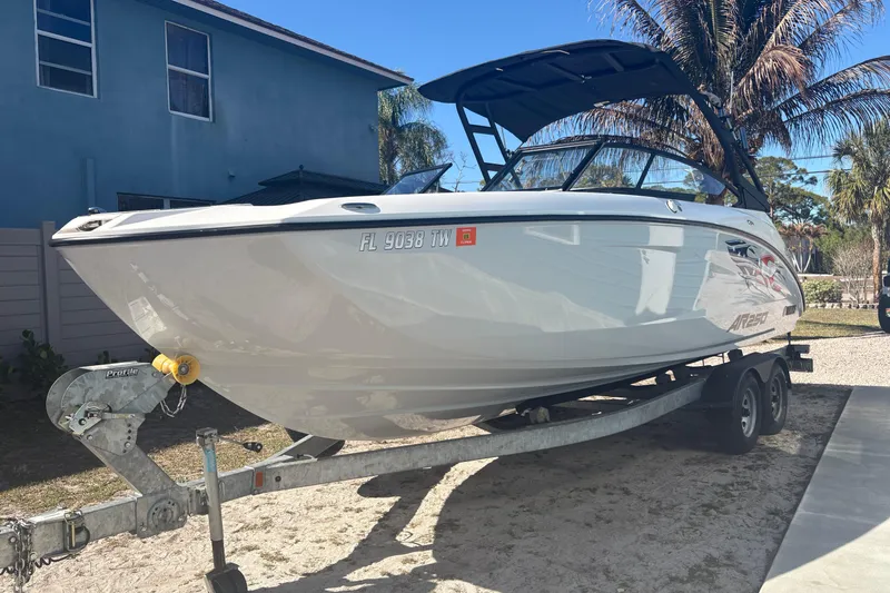 Slide: The Image of 2025 Yamaha Boats AR250 interior with modern dashboard and steering wheel, docked near blue building. - 9
