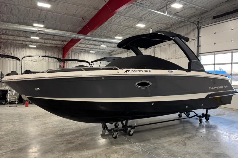 Slide: The Image of 2020 Chaparral 257 SSX boat in indoor storage, sleek black design. - 17