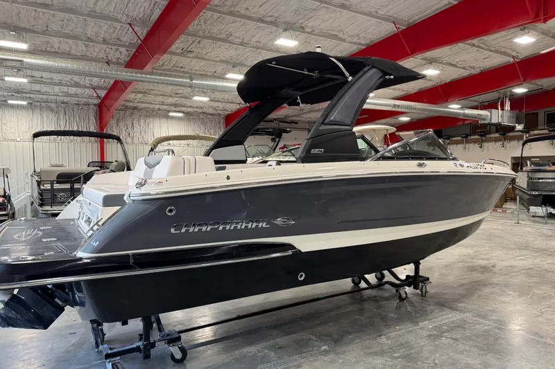 Slide: The Image of 2020 Chaparral 257 SSX boat in showroom with red beams and industrial lighting. - 3