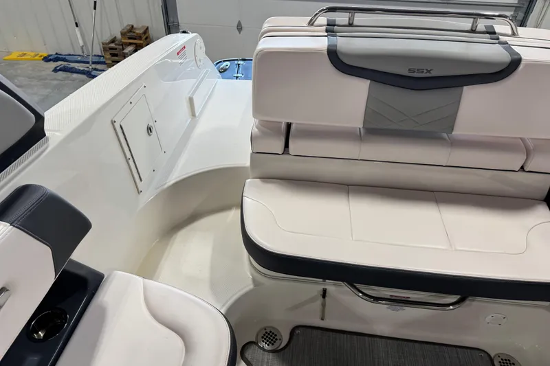 Slide: The Image of 2020 Chaparral 257 SSX boat interior with white seating and storage compartments. - 9