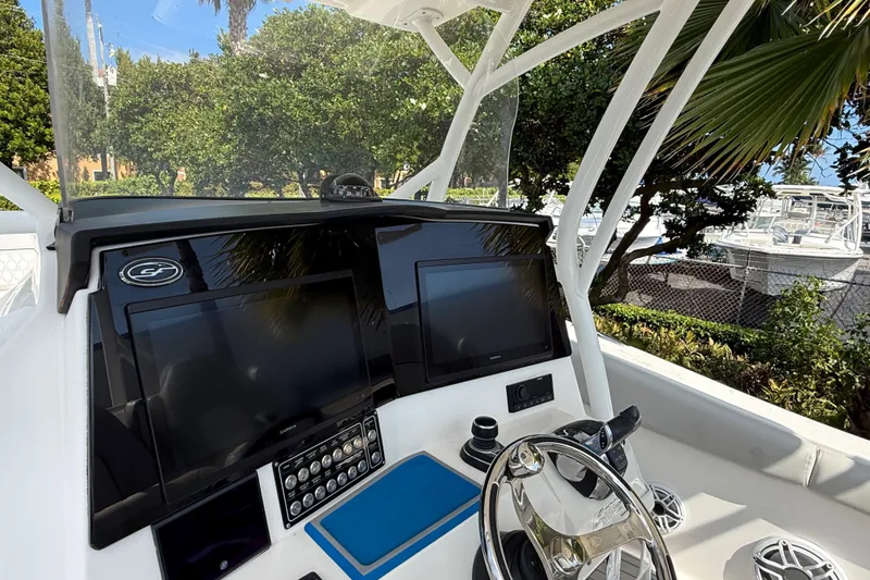 Slide: The Image of 2022 Sea Fox 328 Commander helm with dual displays and steering wheel, surrounded by lush greenery. - 11