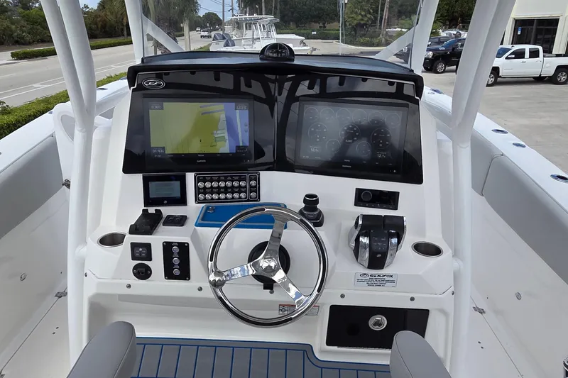 Slide: The Image of 2022 Sea Fox 328 Commander boat dashboard with dual screens and steering wheel. - 32