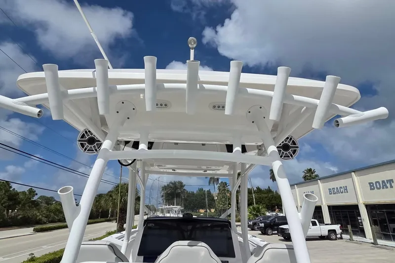 Slide: The Image of 2022 Sea Fox 328 Commander boat with rod holders and speakers, under a clear blue sky. - 37