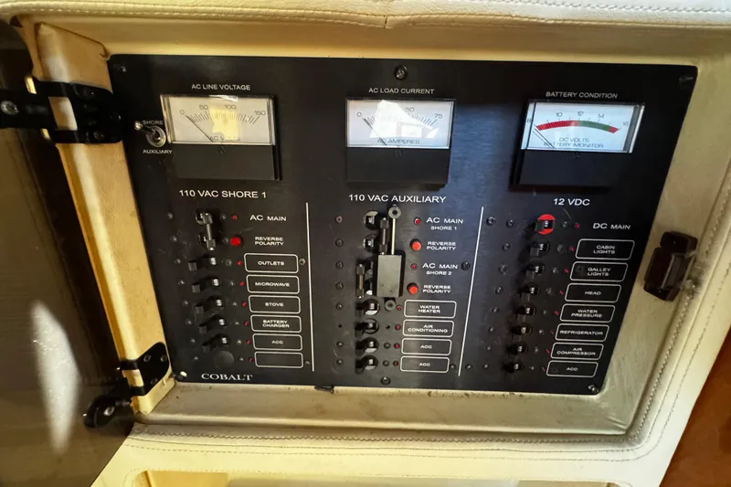 Slide: The Image of Electrical control panel on a 2005 Cobolt 36 boat, featuring voltage and current meters. - 20