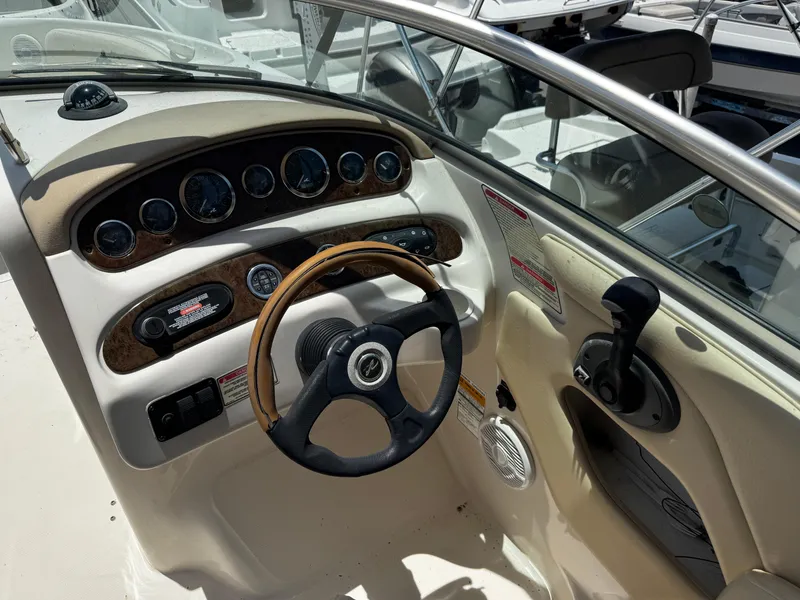 Slide: The Image of 2001 Sea Ray 240 Sundeck dashboard with steering wheel and control panel. - 14