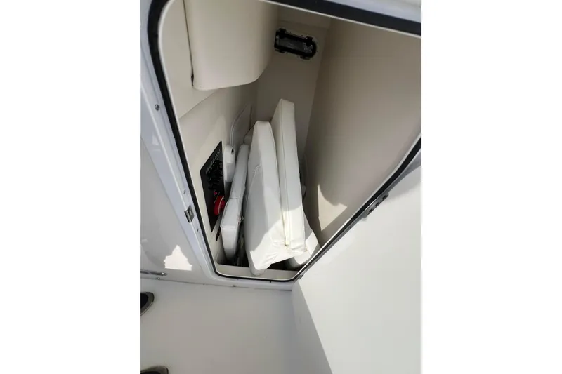 Slide: The Image of Storage compartment in 2019 Regulator 26XO boat, featuring cushions and equipment. - 15