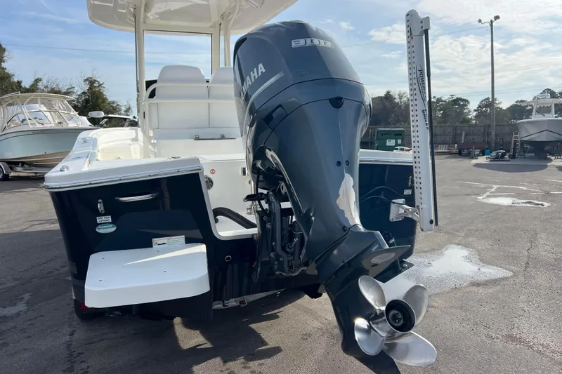 Slide: The Image of 2019 Regulator 26XO boat with Yamaha outboard motor in a marina setting. - 6