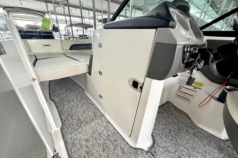 Slide: The Image of 2018 Chaparral Vortex 2430 VRX interior with helm, seating, and carpeted flooring. - 24