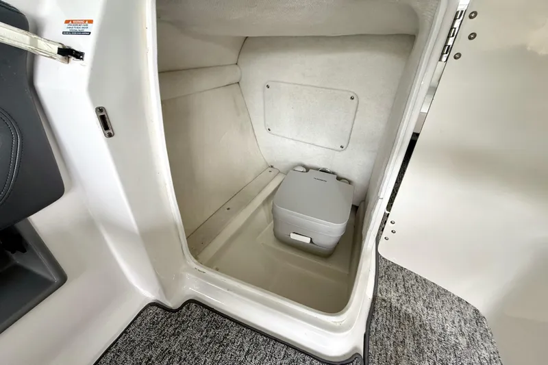 Slide: The Image of 2018 Chaparral Vortex 2430 VRX boat interior with portable toilet compartment. - 26