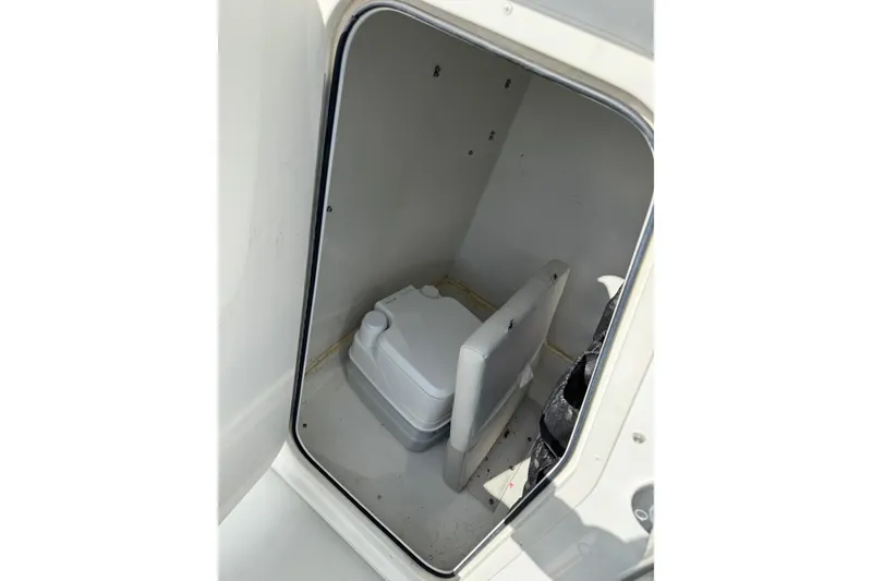 Slide: The Image of 2015 Parker 21SE Center Console boat interior storage compartment with portable toilet. - 11
