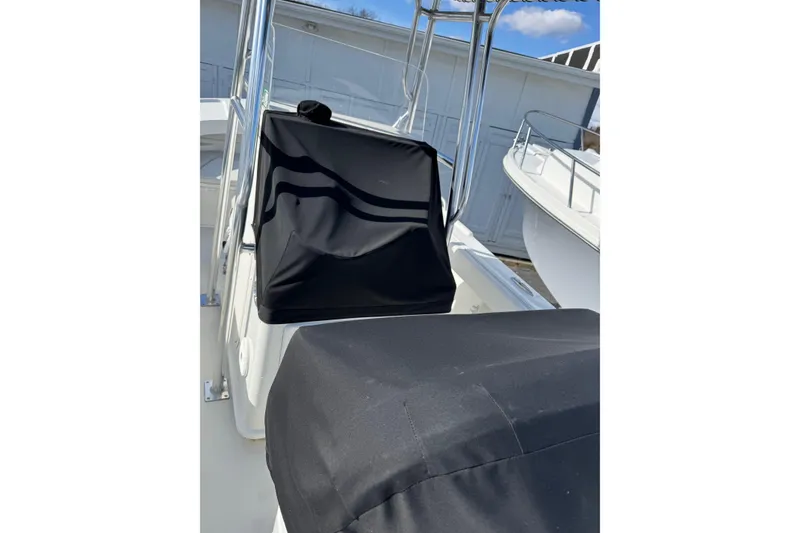 Slide: The Image of 2015 Parker 21SE Center Console boat with protective covers, docked outdoors. - 5