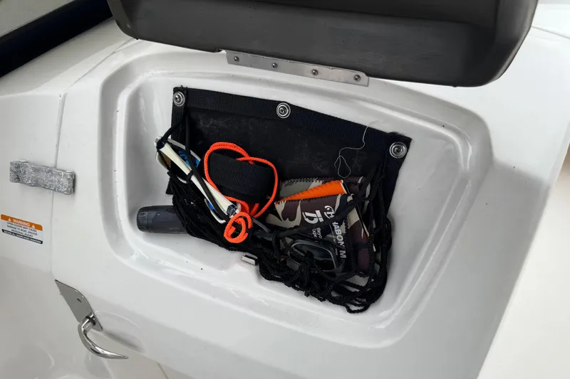 Slide: The Image of Storage compartment on a 2008 Chaparral Sunesta 224 Xtreme boat with various items inside. - 21