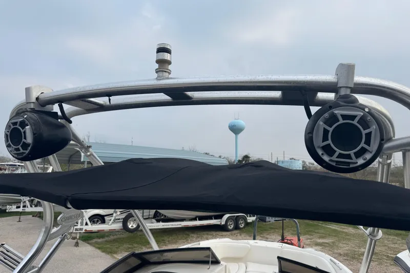 Slide: The Image of 2008 Chaparral Sunesta 224 Xtreme boat with speakers and canopy, parked outdoors. - 34