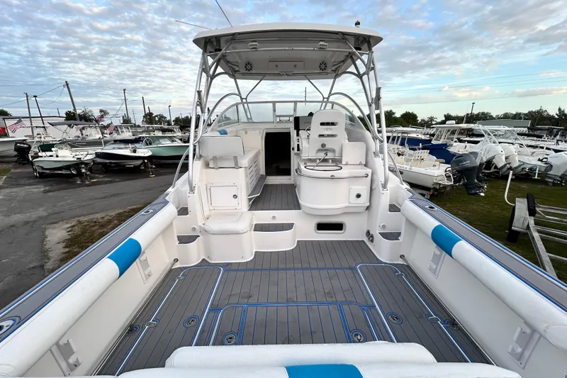 Slide: The Image of 2007 Pro-Line 32 Express boat interior with seating and helm, docked among other boats. - 23