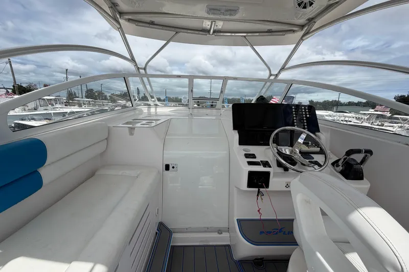 Slide: The Image of 2007 Pro-Line 32 Express boat cockpit with steering wheel and seating under cloudy sky. - 24