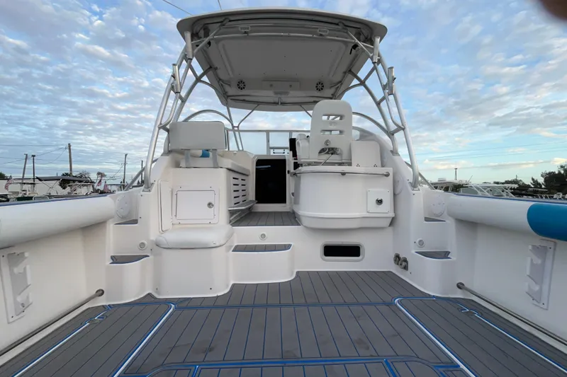 Slide: The Image of 2007 Pro-Line 32 Express boat interior with seating and helm under a cloudy sky. - 26