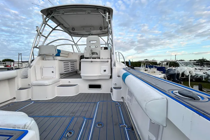 Slide: The Image of 2007 Pro-Line 32 Express boat interior with seating and helm, under a partly cloudy sky. - 28