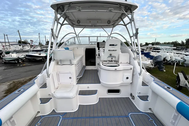 Slide: The Image of 2007 Pro-Line 32 Express boat interior with seating and helm, docked among other boats. - 32