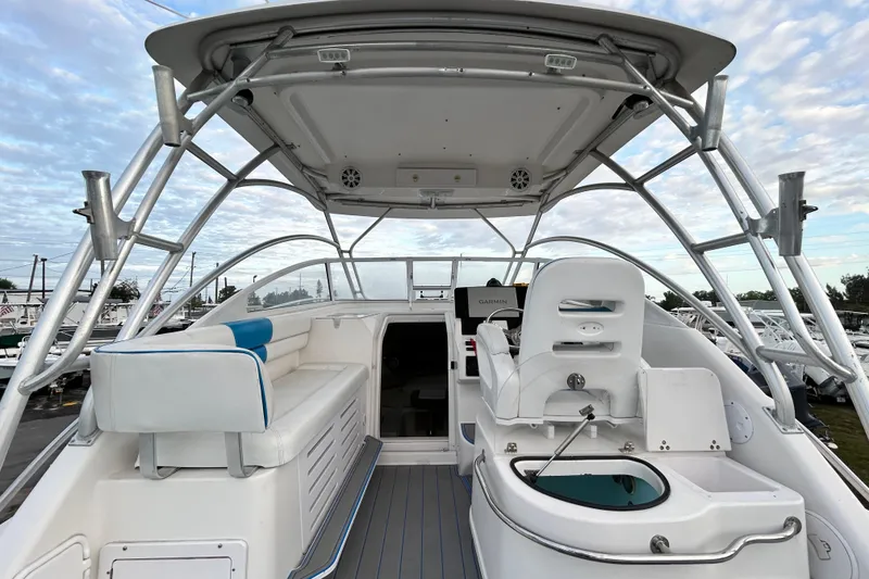 Slide: The Image of 2007 Pro-Line 32 Express boat interior with seating and helm under a cloudy sky. - 33