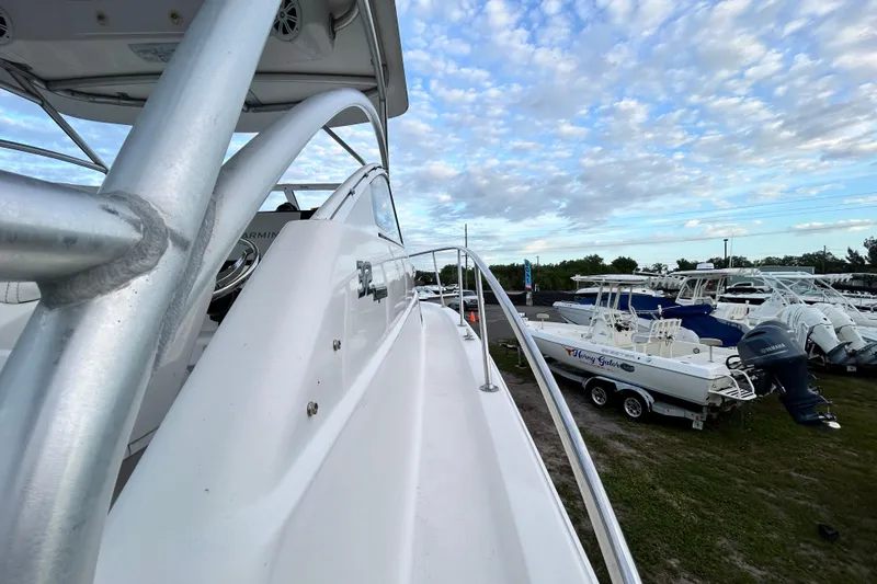 Slide: The Image of 2007 Pro-Line 32 Express boat in marina, surrounded by other vessels under a partly cloudy sky. - 48