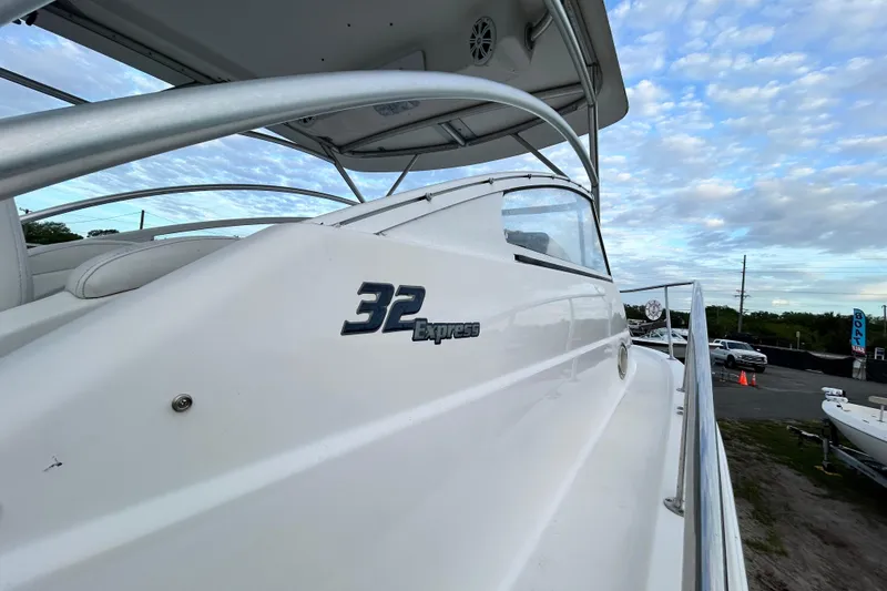 Slide: The Image of 2007 Pro-Line 32 Express boat with sleek white exterior under a cloudy sky. - 49