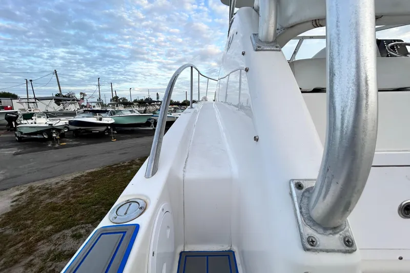 Slide: The Image of 2007 Pro-Line 32 Express boat deck with railing, docked among other boats under a cloudy sky. - 51