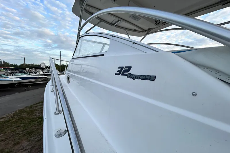 Slide: The Image of 2007 Pro-Line 32 Express boat, sleek design, docked under a partly cloudy sky. - 53