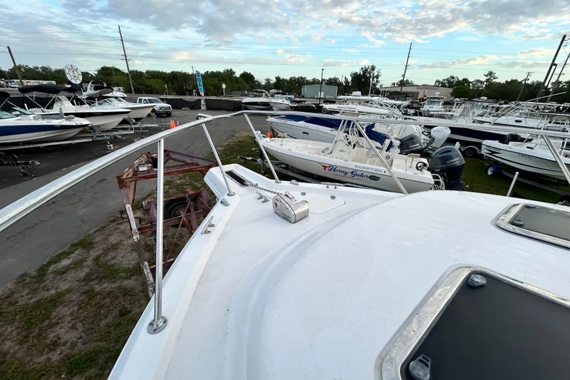 Slide: The Image of 2007 Pro-Line 32 Express boat in a marina with other vessels under a cloudy sky. - 58