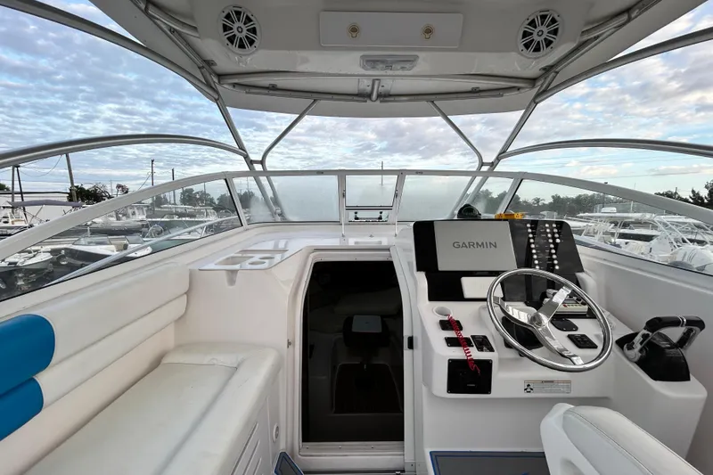 Slide: The Image of 2007 Pro-Line 32 Express boat cockpit with Garmin navigation, white seating, and clear skies. - 68