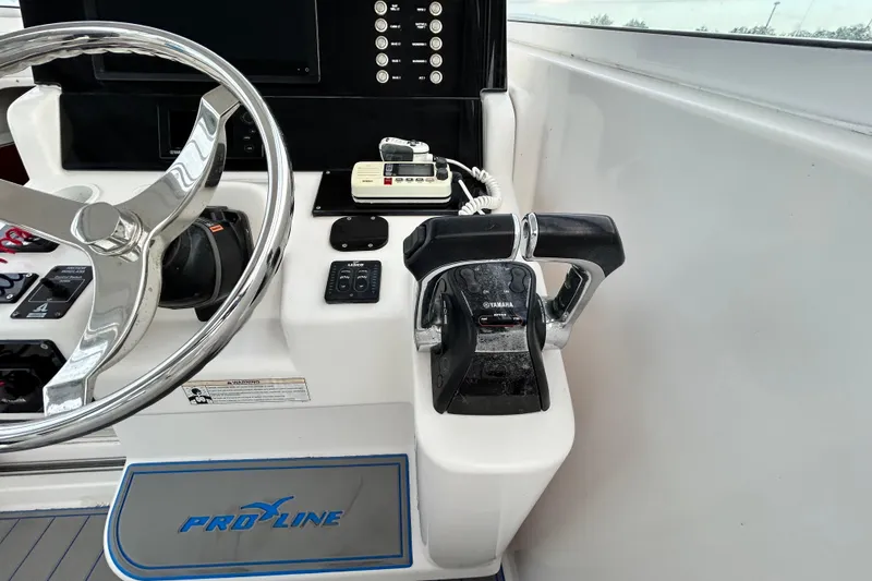 Slide: The Image of 2007 Pro-Line 32 Express boat helm with steering wheel and Yamaha throttle controls. - 70
