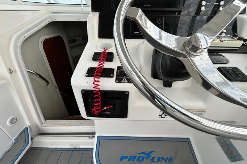 Slide: The Image of 2007 Pro-Line 32 Express boat helm with steering wheel and control panel. - 71