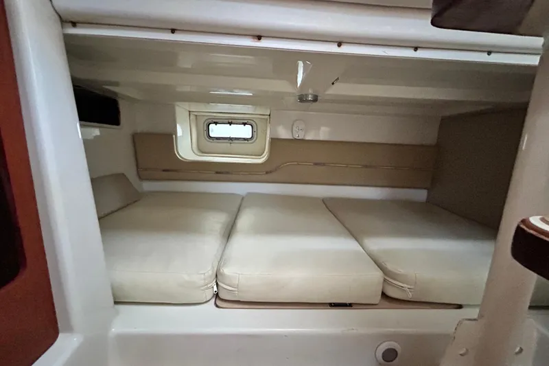 Slide: The Image of 2007 Pro-Line 32 Express cabin interior with beige cushions and small window. - 90
