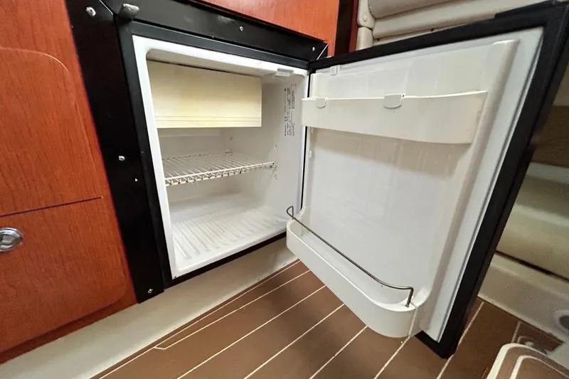 Slide: The Image of Open refrigerator inside 2007 Pro-Line 32 Express boat, showcasing interior shelving. - 92
