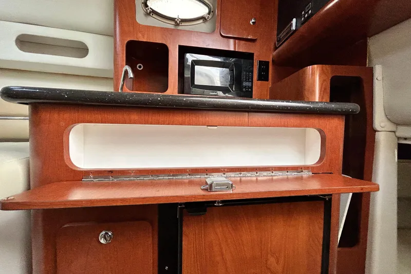 Slide: The Image of 2007 Pro-Line 32 Express boat interior with microwave and wooden cabinetry. - 93
