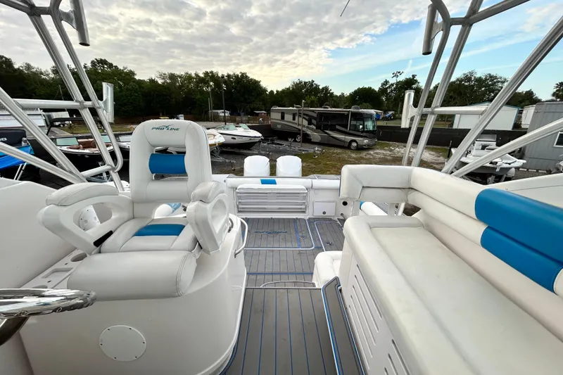 Slide: The Image of 2007 Pro-Line 32 Express boat interior with white and blue seating, docked outdoors. - 96