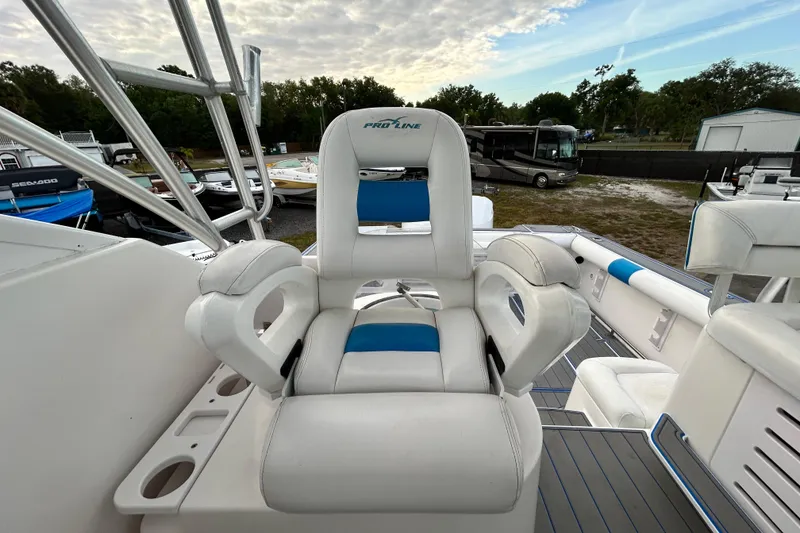 Slide: The Image of 2007 Pro-Line 32 Express boat with white and blue seating, docked outdoors. - 97