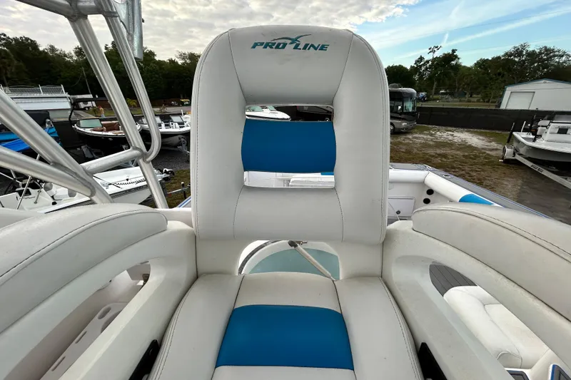 Slide: The Image of 2007 Pro-Line 32 Express boat seat with blue and white upholstery, docked outdoors. - 98