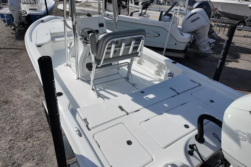 Slide: The Image of 2026 Blazer PureBay 2400 boat with Yamaha engine, docked on gravel. - 3