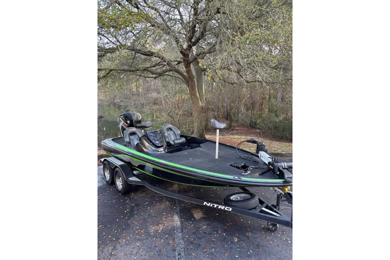 Slide: The Image of 2019 Nitro Z18 boat on trailer, parked near a tree-lined area. - 3