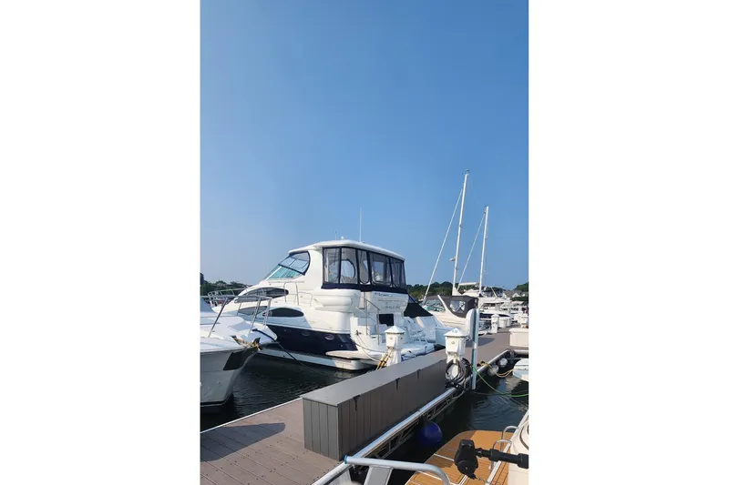 Slide: The Image of 2008 CRUISERS INC 415 Express Motoryacht docked at marina under clear blue sky. - 2