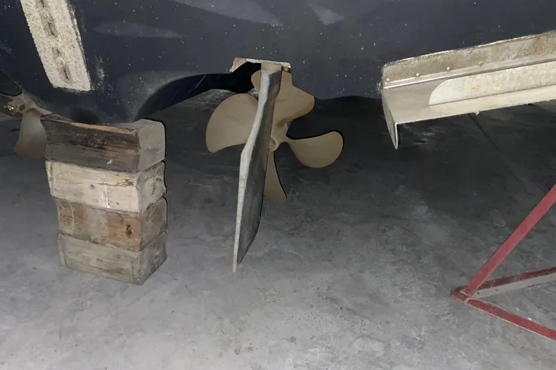 Slide: The Image of 2008 CRUISERS INC 415 Express Motoryacht propeller and rudder on blocks in a garage. - 31