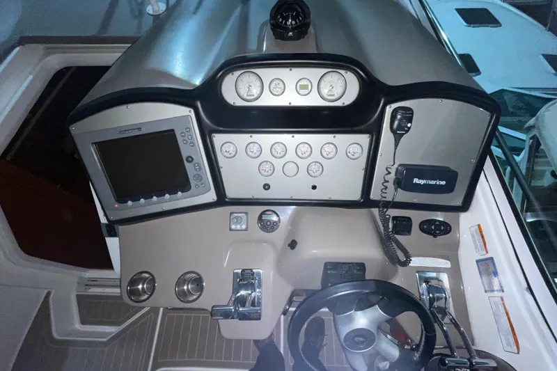 Slide: The Image of 2008 CRUISERS INC 415 Express Motoryacht helm with gauges, Raymarine electronics, and steering wheel. - 11