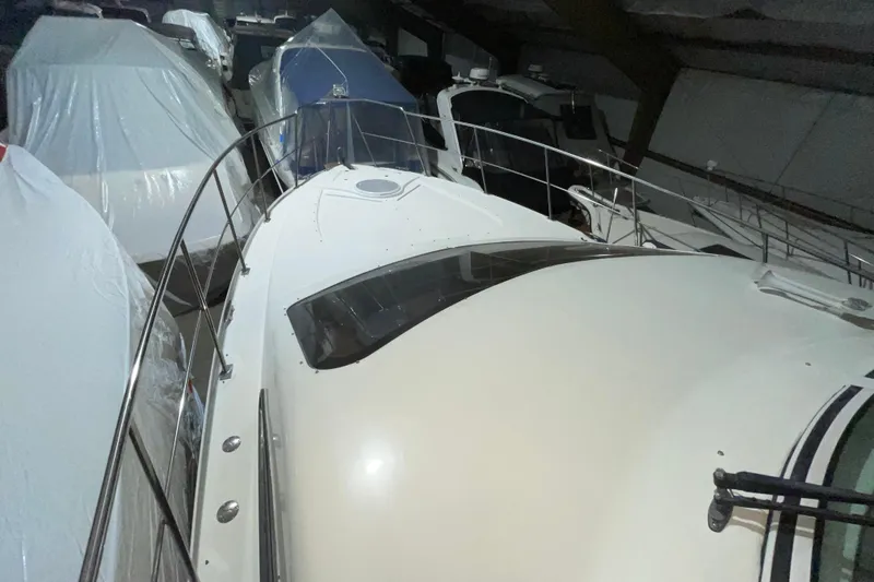 Slide: The Image of 2008 CRUISERS INC 415 Express Motoryacht in storage, surrounded by covered boats. - 7