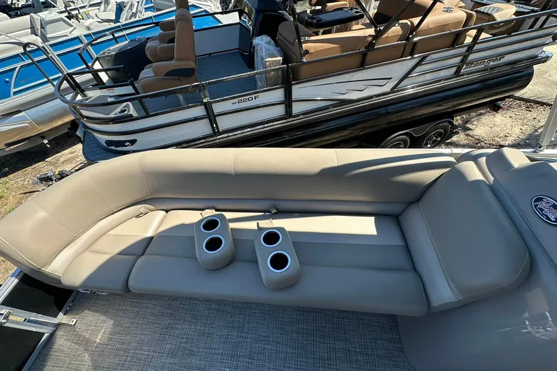 Slide: The Image of 2024 Ranger Reata 200C boat interior with beige seating and cup holders. - 16